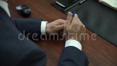 一个人坐在会议室里，紧张不安，手里拿着一支笔